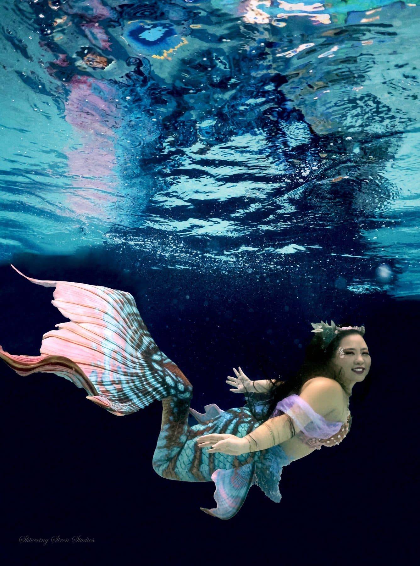 Mermaid Ro swimming beneath rippling teal water